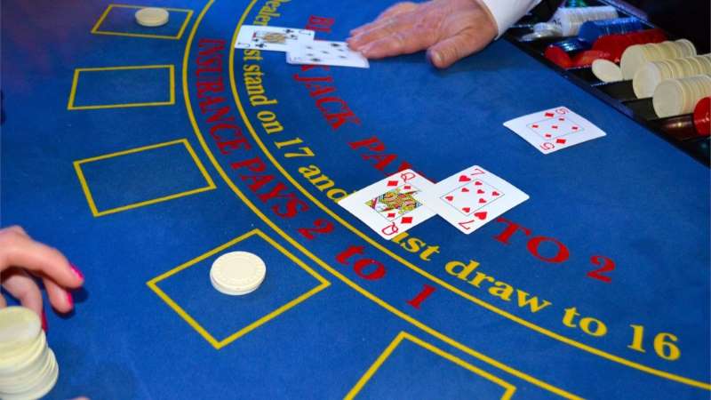 a closeup of a blackjack table with a dealer dealing cards